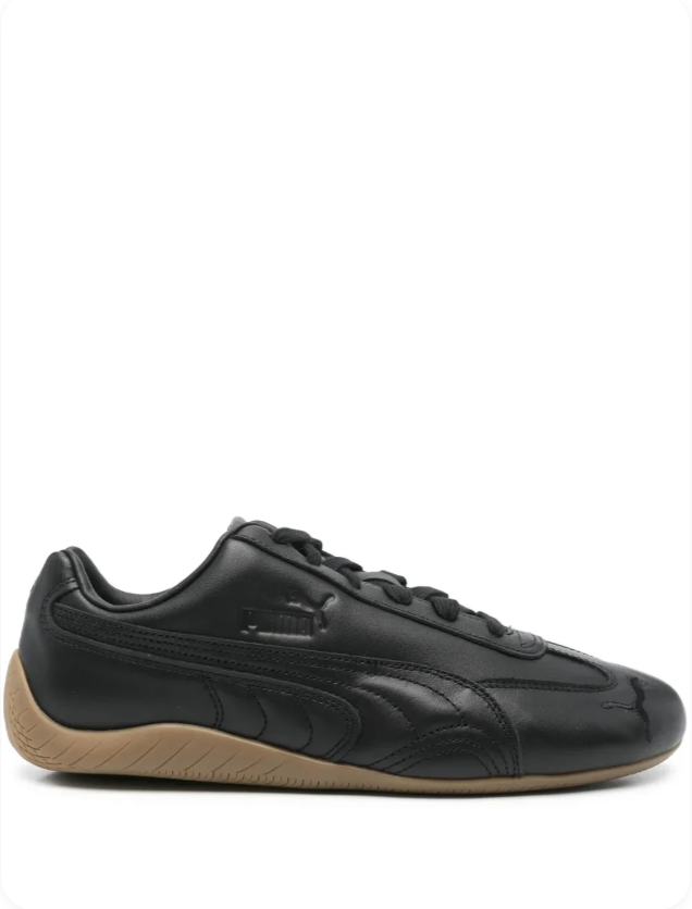 Puma Speedcat OG Black Gum - side profile showing sleek racing flat silhouette, tonal black Puma cat logo and warm translucent gum rubber outsole